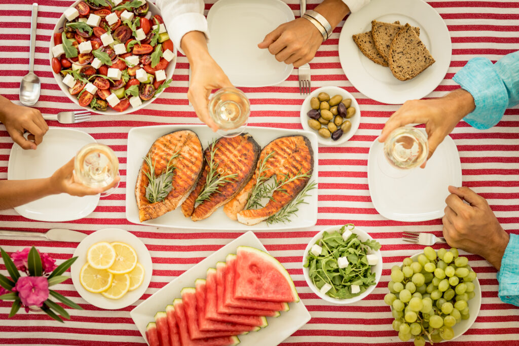 A table spread of food, including fish, fruits, and more.