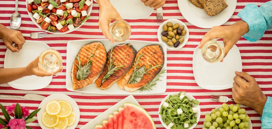 A table spread of food, including fish, fruits, and more.